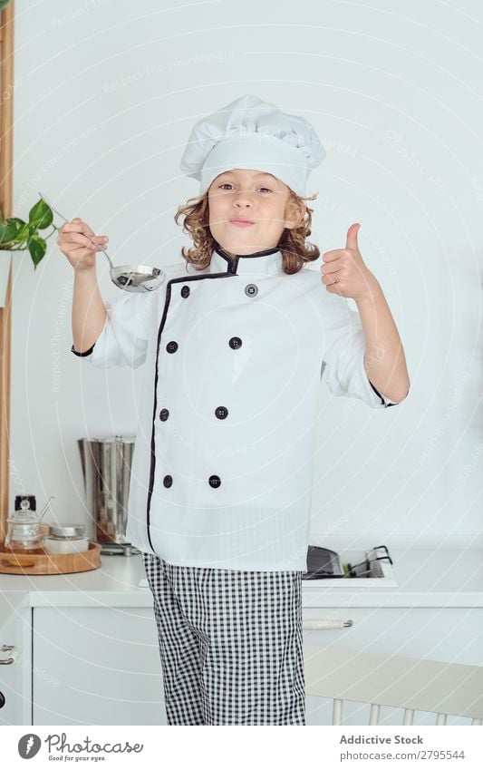 Boy in cook hat holding ladle near mouth in kitchen Cook Boy (child) Kitchen Ladle Mouth chef Child Pot tasting Food Hat Cooking Metal Modern Home Light