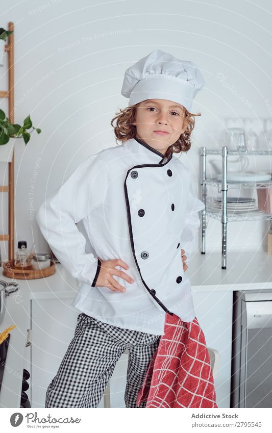 Boy in cook hat in kitchen Cook Boy (child) Kitchen Carrot chef Child Vegetable Hat Fresh Indicate Hand Hip Cooking Modern Funny Home Light preparing Happiness