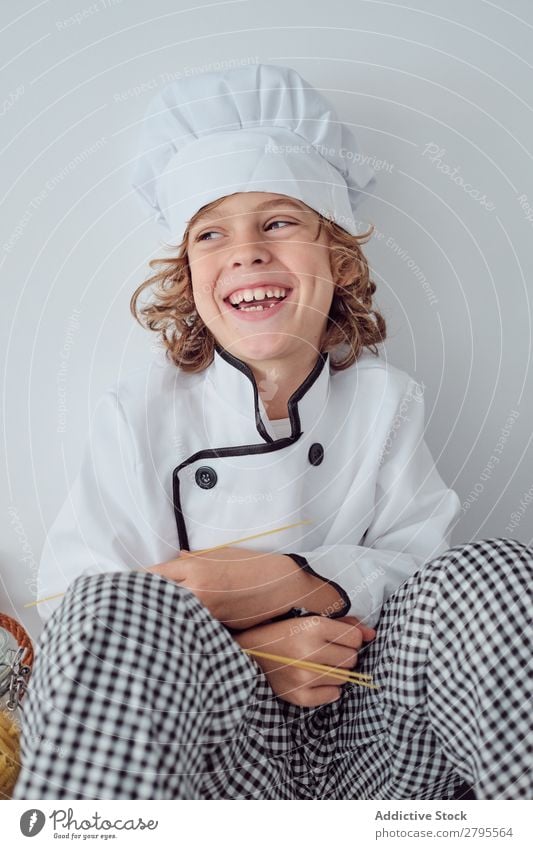 Boy sitting near pots on electric fryer in kitchen Cook Boy (child) Pot Kitchen chef Child Vegetable Hat Stove & Oven Cooking Modern Funny Home Light preparing