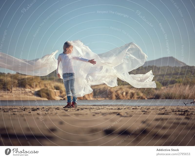 Child entangled in plastic on river coast Boy (child) Plastic textile waving River Coast Side Wind Sand Water Mountain Landscape Beach Help White Sun Joy