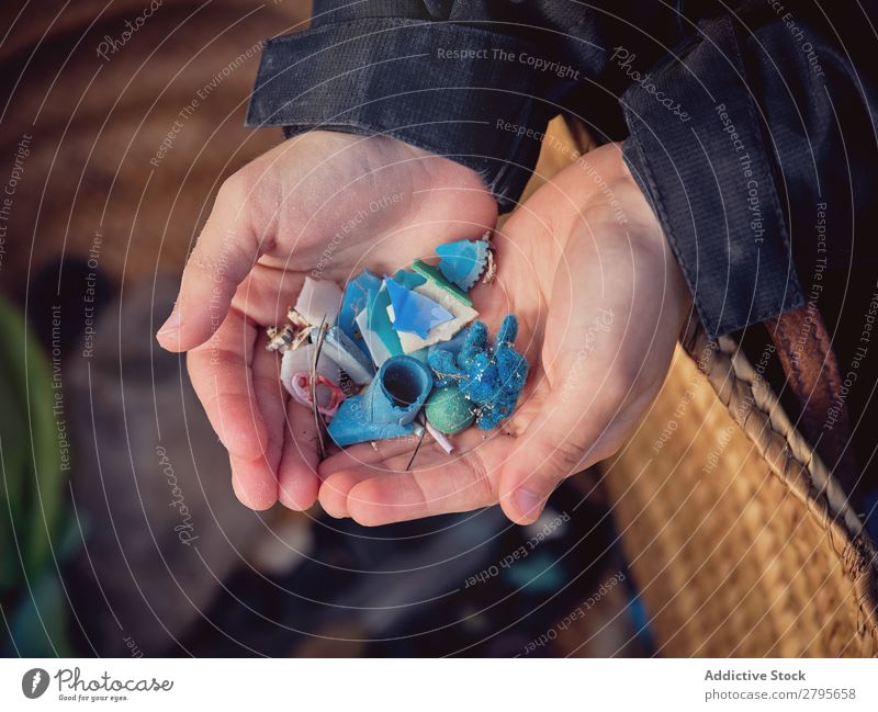 Boy with heap of garbage in hands near basket Trash container Heap Hand Basket Youth (Young adults) Accumulation Container Ground Plastic Boy (child)