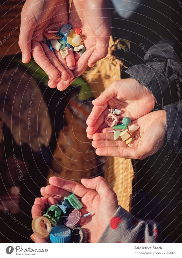 Person and children with heaps of garbage in hands near basket Trash container Heap Hand Basket Child Human being Accumulation Container Plastic cleaning up