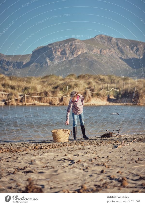 Girl near basket picking up garbage from river shore Trash container Basket River Coast Child Mountain Container cleaning up Environment Nature volunteer