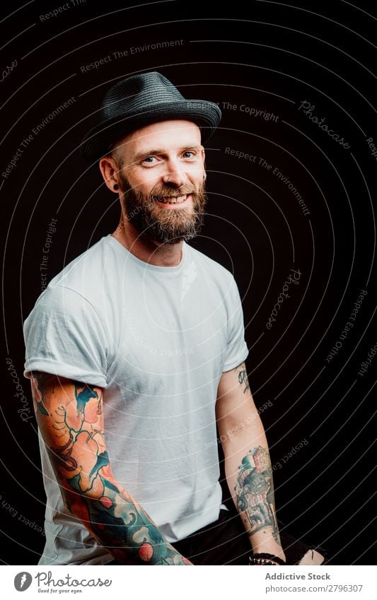 Smiling young guy in hat Man Hipster Tattoo Youth (Young adults) Guy bearded Hat T-shirt Hand Cheerful Easygoing Happy handsome Cool (slang) Style Hip & trendy