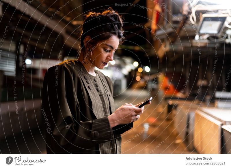 Stylish lady with smartphone on closed market at night Woman Style Markets PDA Hipster Night Tel Aviv Israel Street Cellphone using small shop Closed