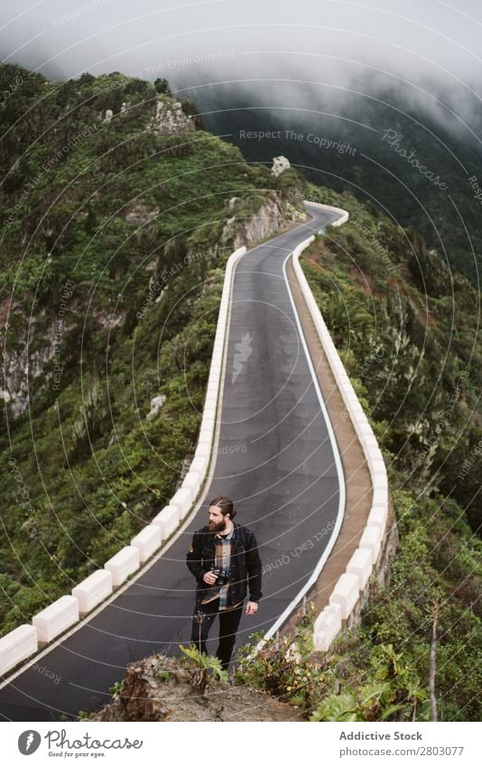 Bearded photographer looking away on mountain road traveler photo camera Mountain Street Looking away Man bearded Style playa norte Spain Dune Tourist Trip