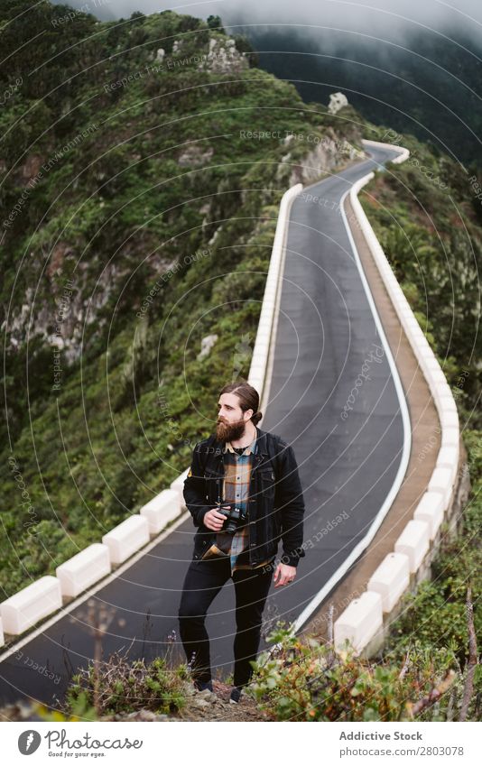 Bearded photographer looking away on mountain road traveler photo camera Mountain Street Looking away Man bearded Style playa norte Spain Dune Tourist Trip