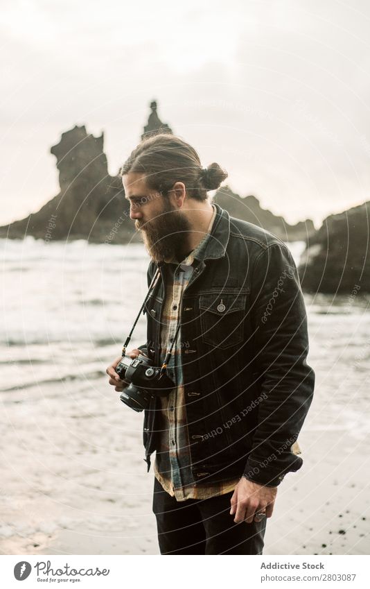 Bearded photographer standing near sea Man photo camera Ocean Vacation & Travel Coast Nature Looking away bearded Waves Storm Landscape Spain playa norte