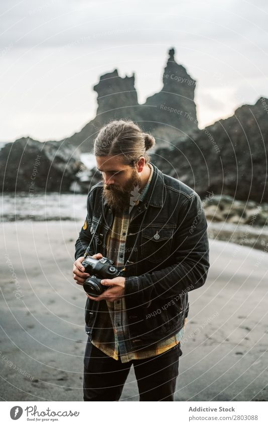 Bearded photographer standing near sea Man photo camera Ocean Vacation & Travel Coast Nature bearded Waves Storm Landscape Spain playa norte Professional