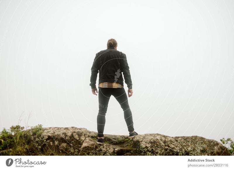 Anonymous man standing on cliff near countryside road Man Fog Landscape Street Cliff Spain playa norte Rock Vacation & Travel explore admiring Weather Trip