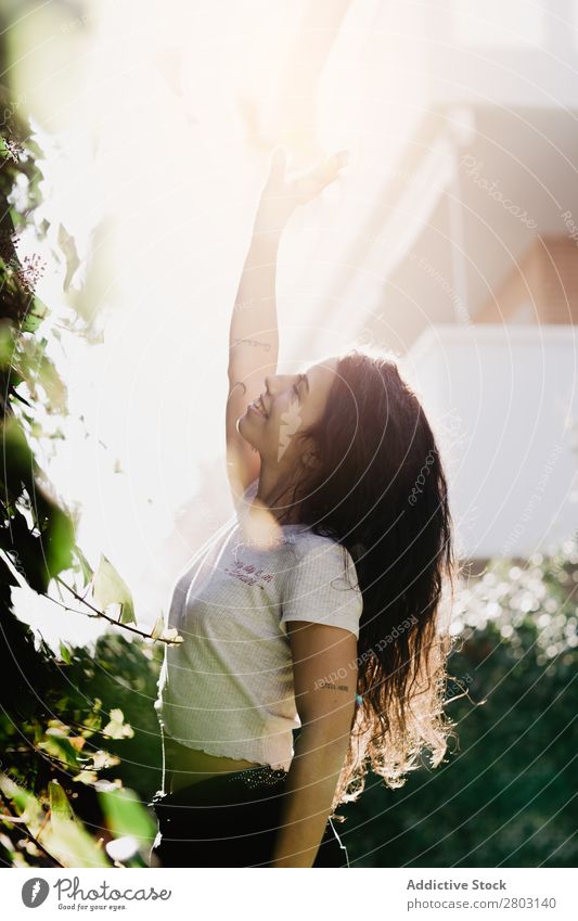 Cheerful woman waving hand in garden Woman Backyard Smiling Bushes Youth (Young adults) Sunbeam Day Gesture Garden Summer Style Easygoing Hip & trendy Park