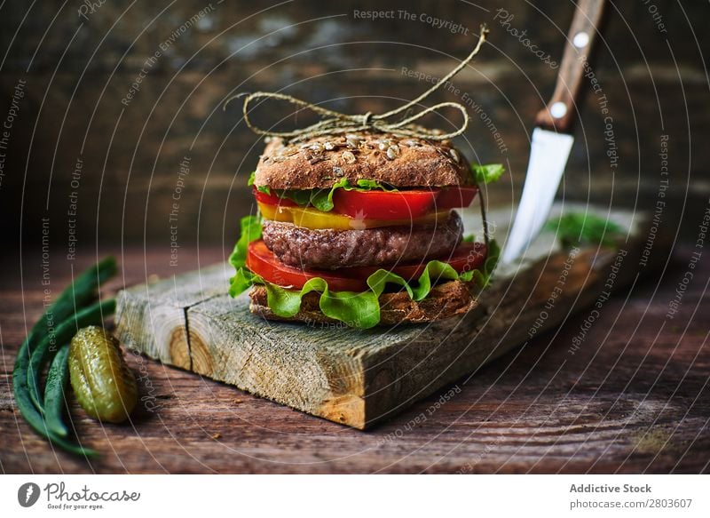 Delicious burger on wooden board Food Board Onion Pickles Preparation Lunch Cooking Meal Roll Speed Gourmet Unhealthy Bread tied Thread Rustic Tasty yummy