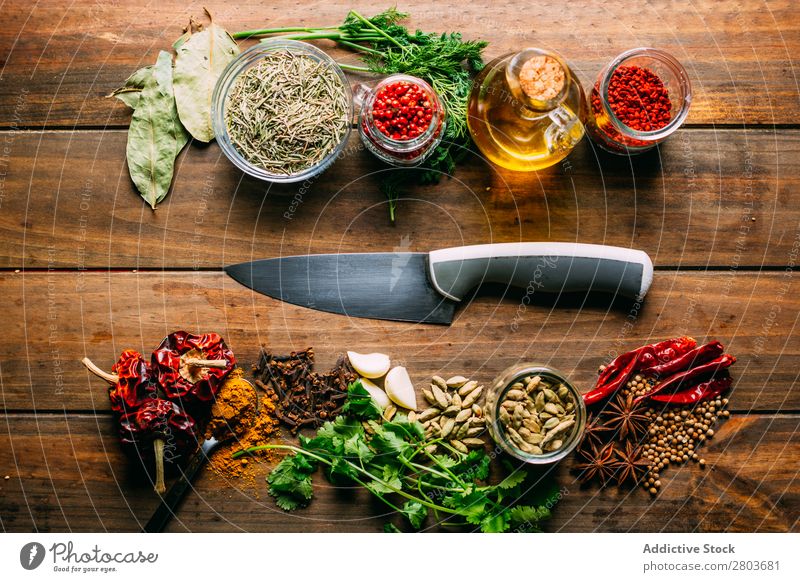 Spices and oil near knife Herbs and spices Oil Knives Table assortment Cooking Ingredients Set Fresh Dill Parsley Garlic anise turmeric Cardamom Coriander Chili