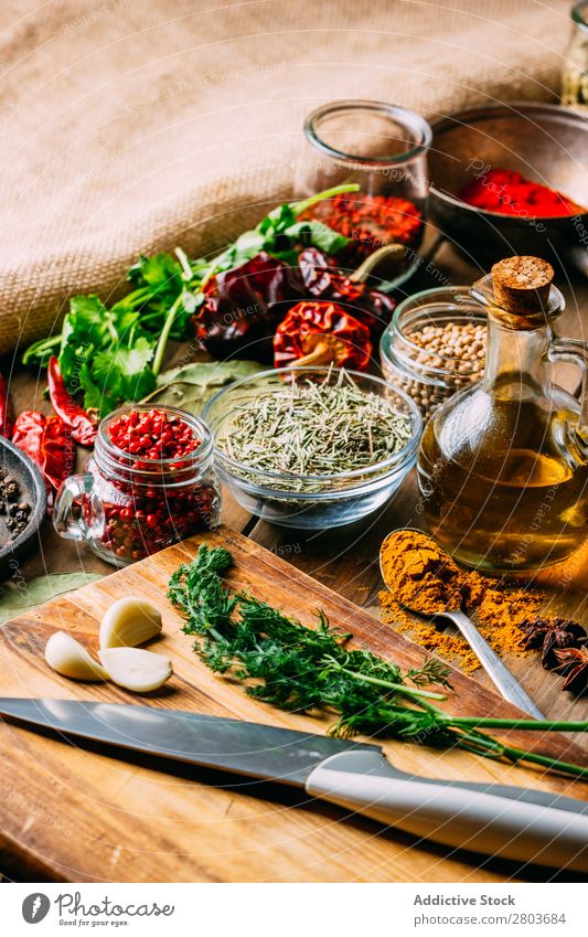 Spices and oil near knife Herbs and spices Oil Knives Table assortment Cooking Ingredients Set Fresh Dill Parsley Garlic anise turmeric Cardamom Coriander Chili