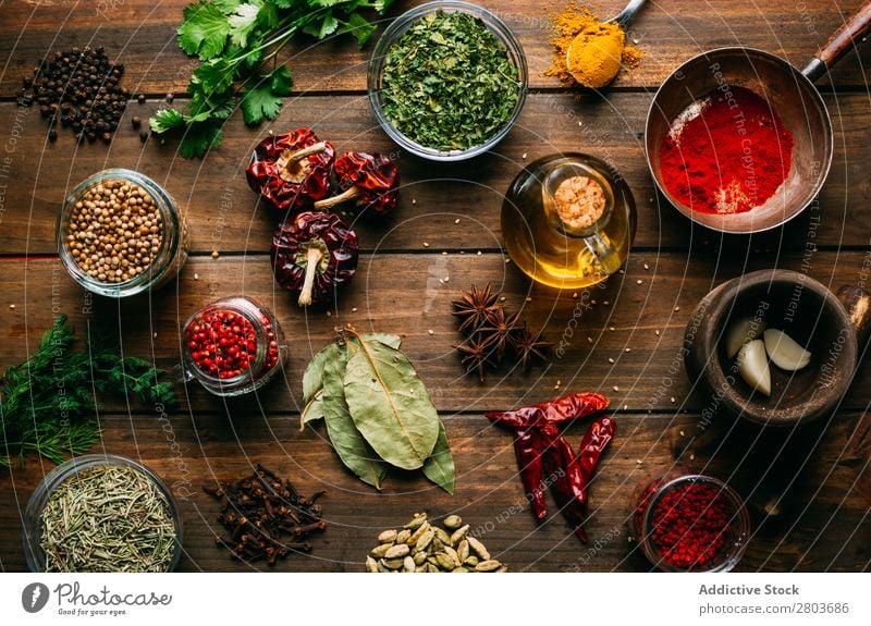 Spices and oil on table Herbs and spices Oil Table assortment Cooking Ingredients Set Fresh Dill Parsley Garlic anise turmeric Cardamom Coriander Chili