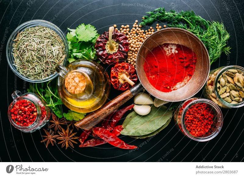 Assorted spices near fresh oil Herbs and spices Oil assortment Cooking Ingredients Set Fresh Dill Parsley Garlic anise Cardamom Coriander Chili pink pepper