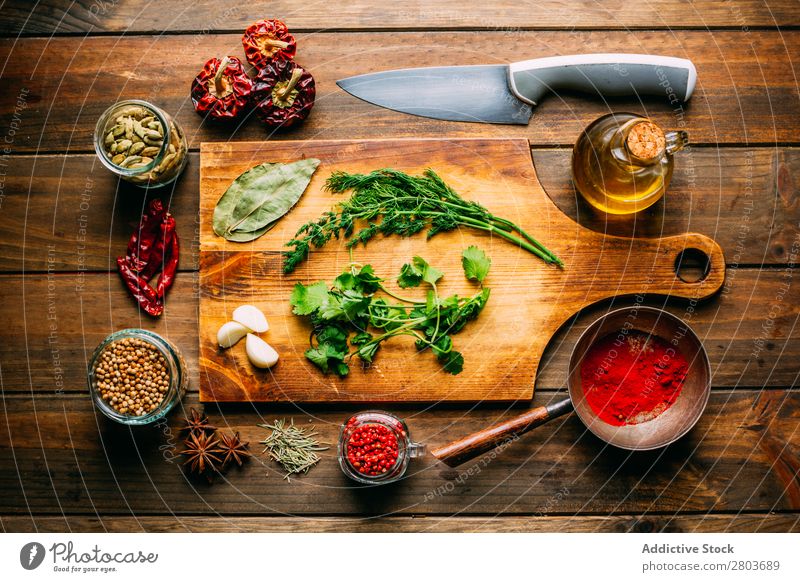 Spices and oil near knife Herbs and spices Oil Knives Table assortment Cooking Ingredients Set Fresh Dill Parsley Garlic anise turmeric Cardamom Coriander Chili