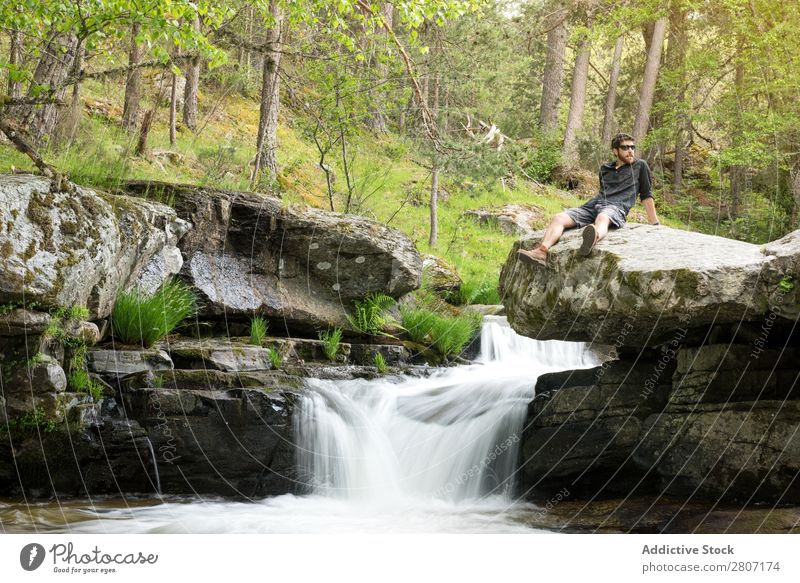 Young man enjoys rest at the waterfall after adventure Water Nature Summer Vacation & Travel Man enjoying Waterfall Healthy Body Conceptual design Green Fresh