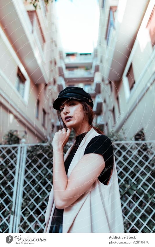 Pretty stylish woman putting on cap Woman Style Youth (Young adults) Street Beautiful Cap Fence City Fashion pretty Attractive Model Human being