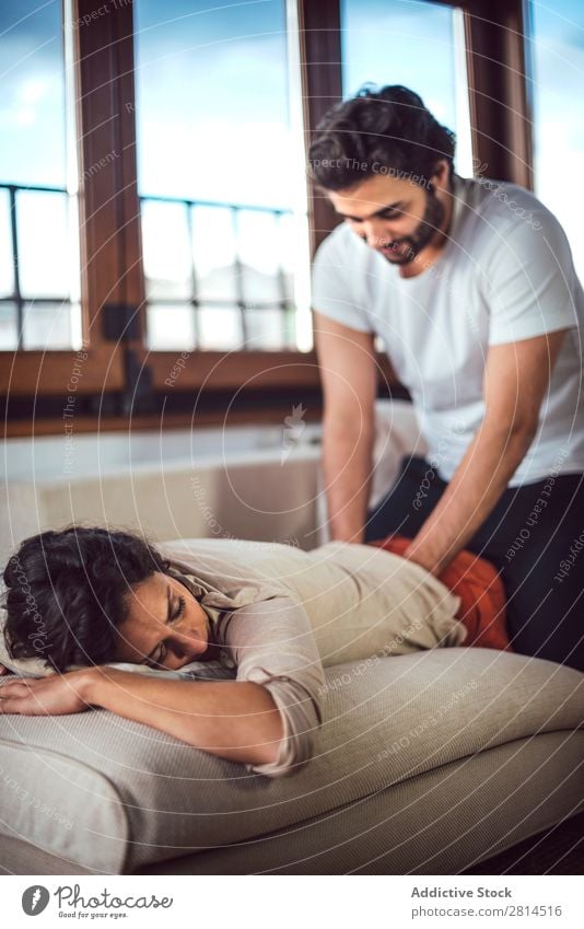 Young couple. Man massaging a woman Woman Barefoot couch massaging Couple Heterosexual couple Easygoing Human being Adults Lie (Untruth) Home Massage Couch