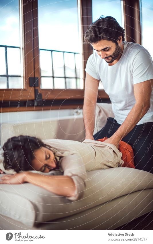 Young couple. Man massaging a woman Woman Barefoot couch massaging Couple Heterosexual couple Easygoing Human being Adults Lie (Untruth) Home Massage Couch