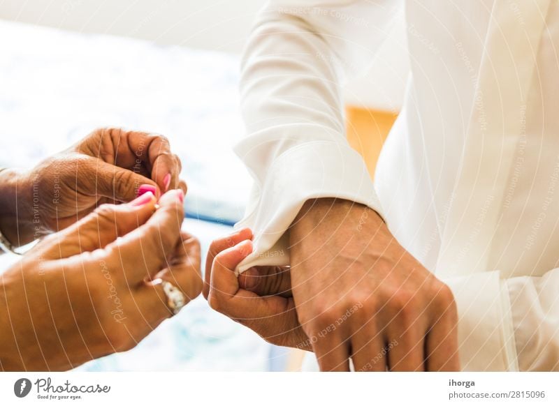 A groom putting on cuff-links in his wedding day. Luxury Elegant Style Wedding Office Business Human being Masculine Man Adults Couple Partner Hand 2 Fashion