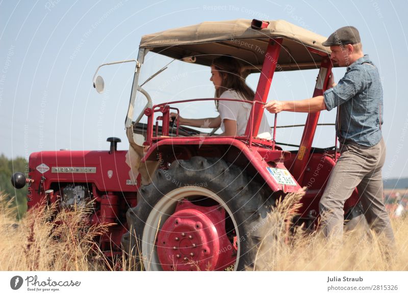 Tractor Drive Field Work Woman Adults Man 2 Human being 30 - 45 years Environment Sky Summer Beautiful weather Barleyfield Suspenders Cap Brunette Long-haired