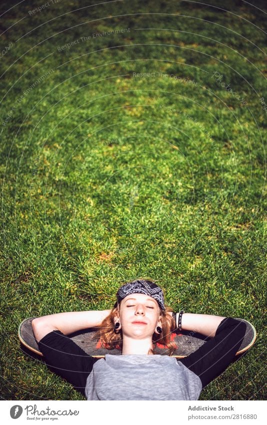 Young woman resting in the grass after practicing skateboard chill Girl Hipster Skateboard Youth (Young adults) Park Light Rest Lie (Untruth) Woman Relaxation