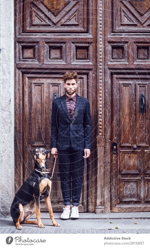 Handsome elegant young fashion man in trendy costume suit with a dog, old wooden door background Suit Man Gentleman Fashion fashionable Clothing Style Model