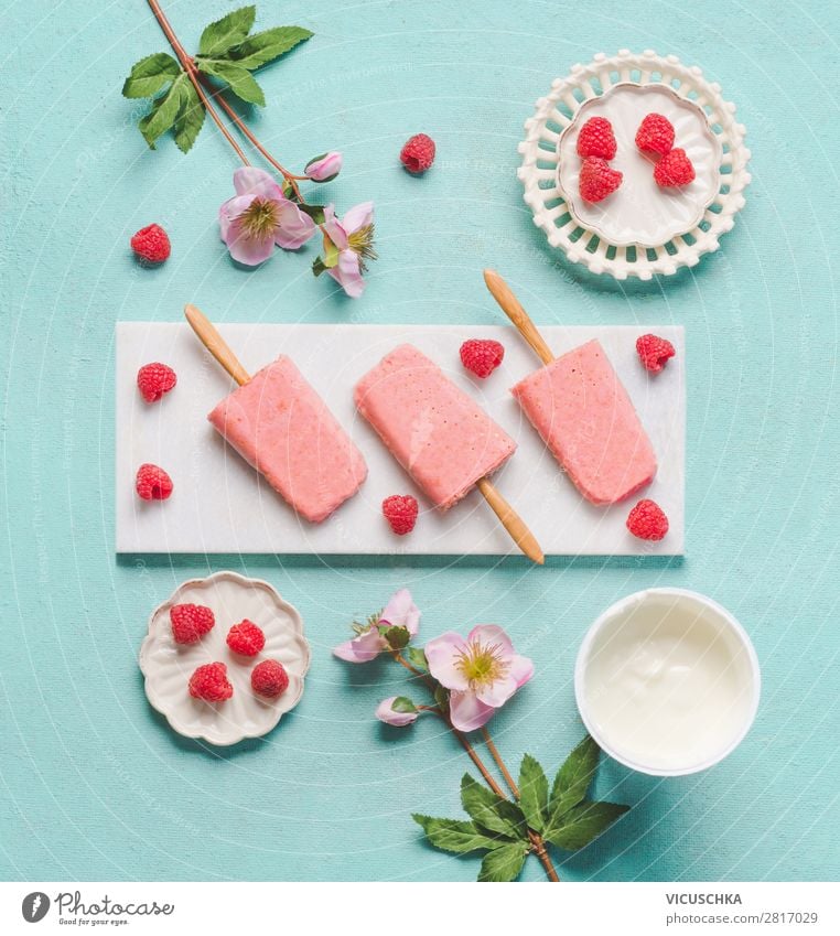 Homemade raspberries yogurt ice cream with ingredients on light blue turquoise background , top view, flat lay. Popsicle ice. Summer food.