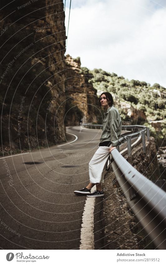 Woman leaning on road fence Roadside Mountain Lean Fence Vacation & Travel Street Summer Girl Youth (Young adults) Human being Adventure Loneliness Nature Trip