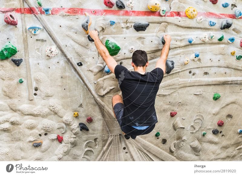 A Man practicing rock climbing on artificial wall indoors. Lifestyle Joy Leisure and hobbies Sports Climbing Mountaineering Adults 1 Human being 18 - 30 years