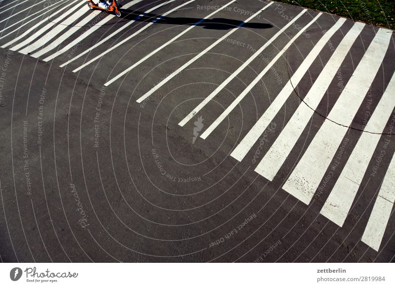 Rolling on strips Asphalt Driving Spring Light Child Playground Signs and labeling Scooter Shadow Summer Playing Stripe Line Copy Space Movement Sports