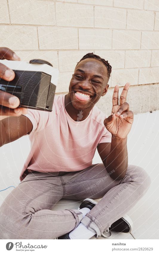 Young man holding an old analog camera Lifestyle Style Joy Hair and hairstyles Face Leisure and hobbies Camera Technology Entertainment electronics Human being