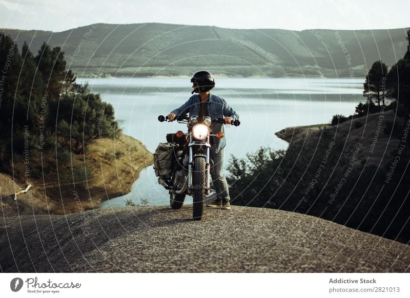 Man on bike posing on landscape Landscape Motorcycle Rock Cliff Wanderlust Transport Vacation & Travel scenery Lake Motorcyclist Stand Freedom Track Adventure