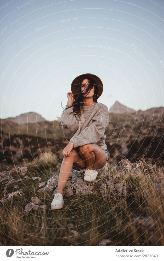 Woman in windy day on rock Rock Sit Mountain Hat Flying Hair Vacation & Travel Top Freedom Youth (Young adults) Nature Tourist Peak Adventure Landscape Action