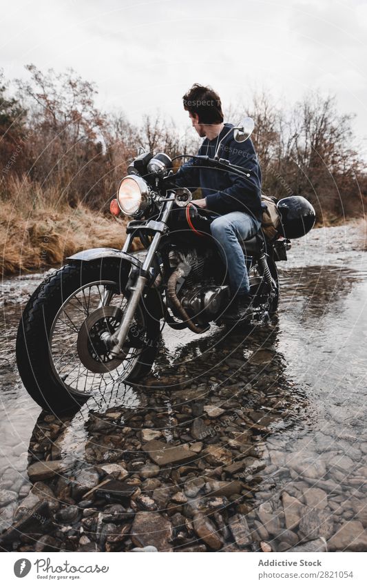 Man crossing creek on motorcycle Motorcycle Brook Transport Vehicle riding Freedom Nature Offroad Water Wanderlust Snow Winter Posture traveler Self-confident