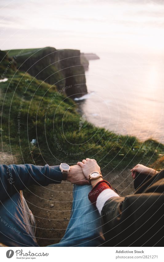 Crop couple holding hands Cliff Ocean Vantage point Landscape Water Coast Vacation & Travel Nature seascape Summer Sky Rock Island Tourism Sunlight Sunset