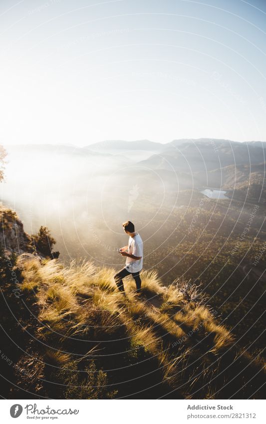 Man walking on slope of hill Mountain Landscape Vantage point PDA Network Weather Walking Relaxation Technology Tourism scenery traveler Panorama (Format)