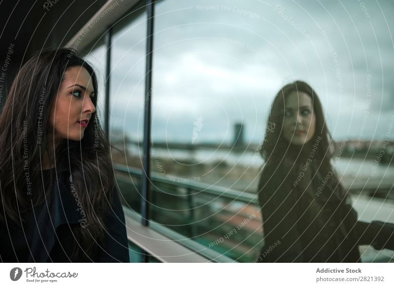 Woman looking at reflection in window pretty Youth (Young adults) Beautiful Stand Window Reflection Building Balcony City Town Brunette Attractive Human being