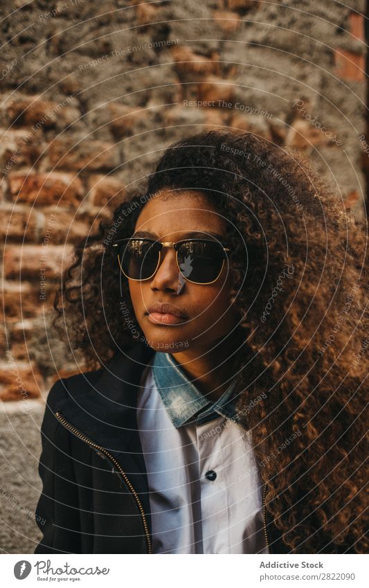 Stylish woman at brick wall Woman pretty Beautiful Ethnic Black Curly African Youth (Young adults) Stand Wall (building) Brick Street Sunglasses Brunette