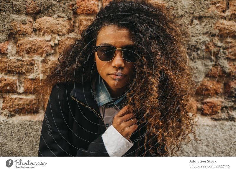 Stylish woman at brick wall Woman pretty Beautiful Ethnic Black Curly African Youth (Young adults) Stand Wall (building) Brick Street Sunglasses Brunette