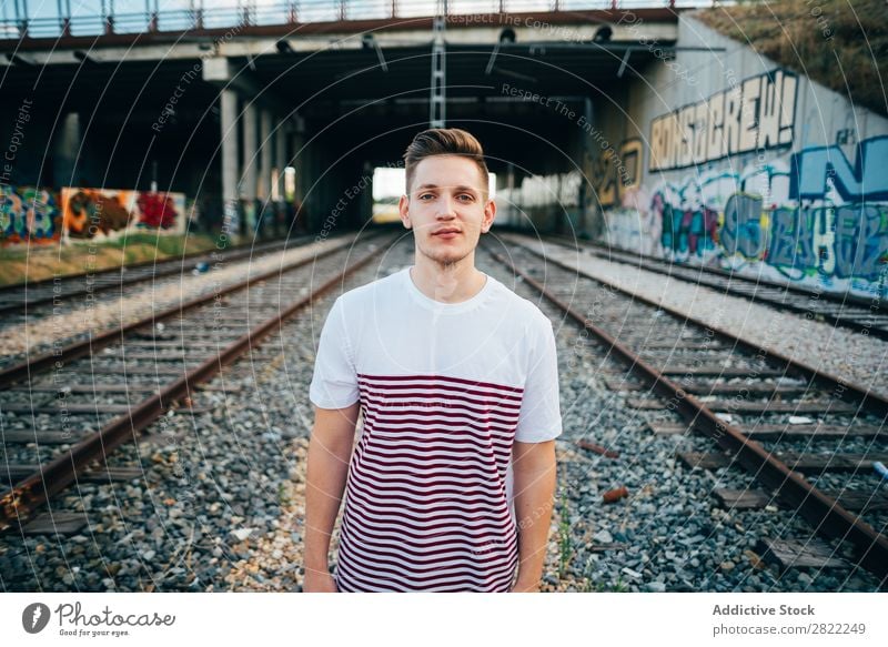 Young man at city railway Man Railroad Town Cheerful Stand Vacation & Travel Graffiti Wall (building) Transport Human being Station City Youth (Young adults)