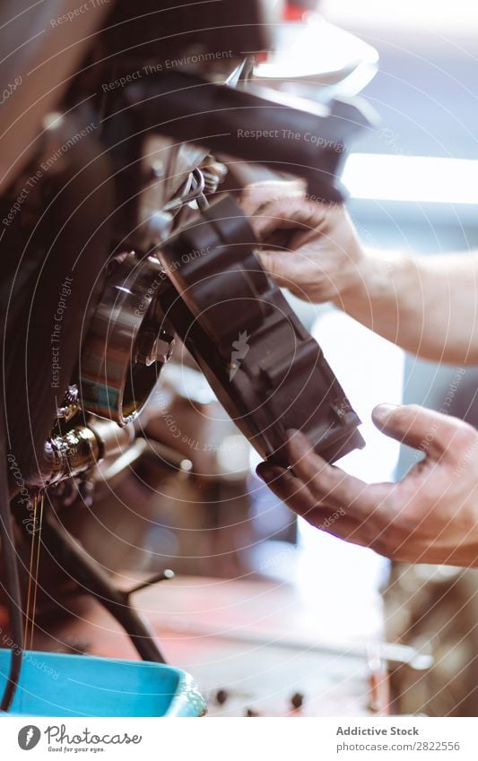 Man putting part on bike Human being Maintenance Close-up Detail Part Hand Employees &amp; Colleagues Motorcycle Workshop Engines Transport Vehicle Garage