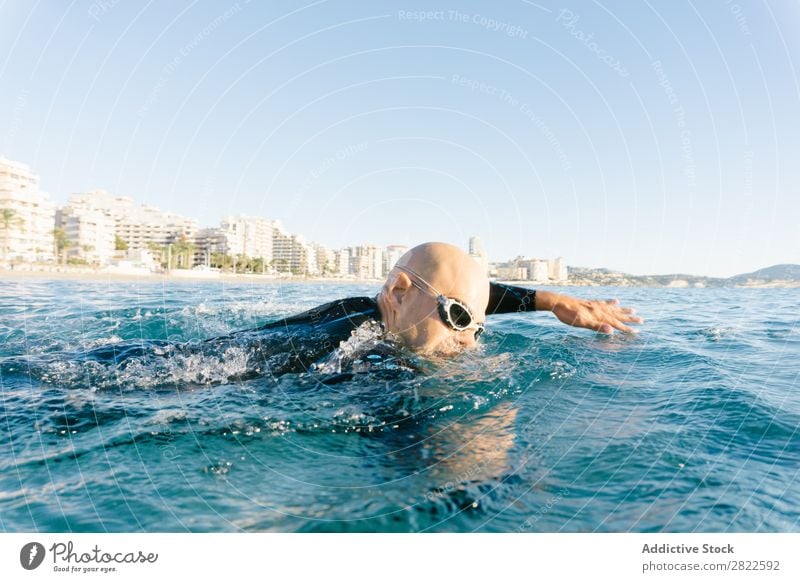 Man in wetsuit swimming in ocean Wetsuit Swimming Ocean Sports Athlete Aquatics Movement Action Water Vacation & Travel Rowing Leisure and hobbies Sunlight