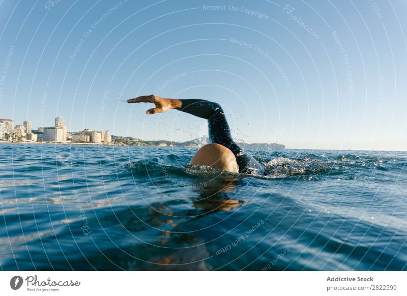 Man in wetsuit swimming in ocean Wetsuit Swimming Ocean Sports Athlete Aquatics Movement Action Water Vacation & Travel Rowing Leisure and hobbies Sunlight