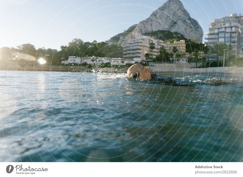 Man in wetsuit swimming in ocean Wetsuit Swimming Ocean Sports Athlete Aquatics Movement Action Water Vacation & Travel Rowing Leisure and hobbies Sunlight