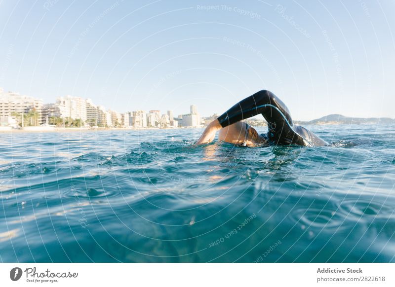 Man in wetsuit swimming in ocean Wetsuit Swimming Ocean Sports Athlete Aquatics Movement Action Water Vacation & Travel Rowing Leisure and hobbies Sunlight