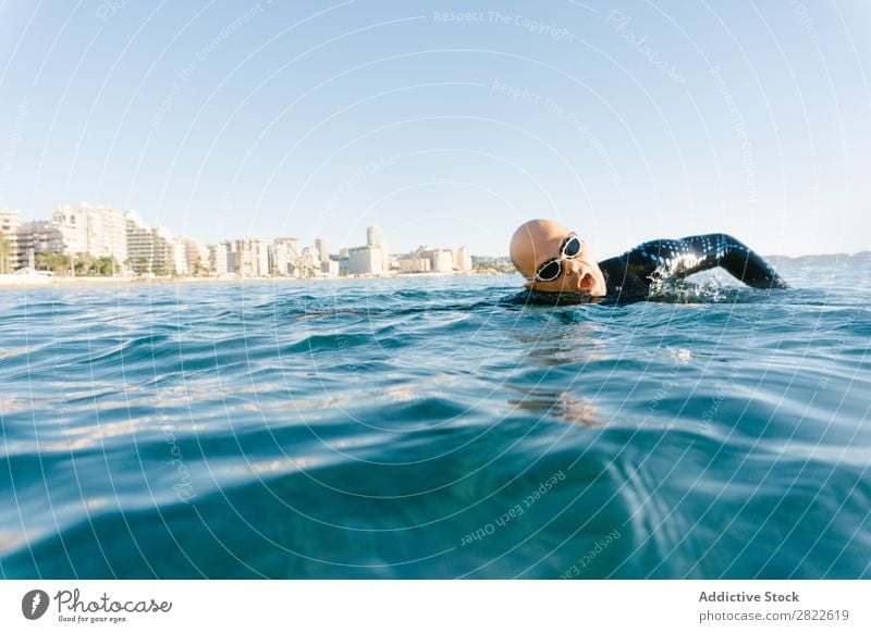 Man in wetsuit swimming in ocean Wetsuit Swimming Ocean Sports Athlete Aquatics Movement Action Water Vacation & Travel Rowing Leisure and hobbies Sunlight