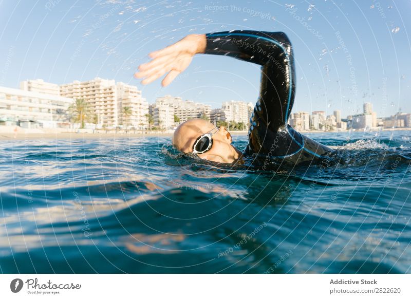 Man in wetsuit swimming in ocean Wetsuit Swimming Ocean Sports Athlete Aquatics Movement Action Water Vacation & Travel Rowing Leisure and hobbies Sunlight